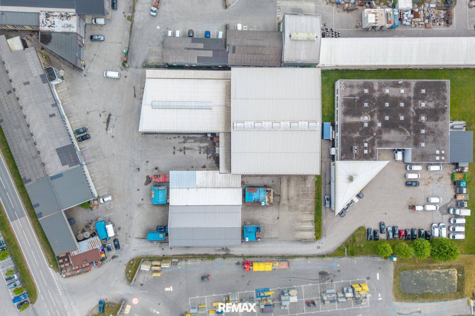 Senkrechte Luftaufnahme des Industrieparks mit detaillierter Ansicht der Dächer und Parkplätze.