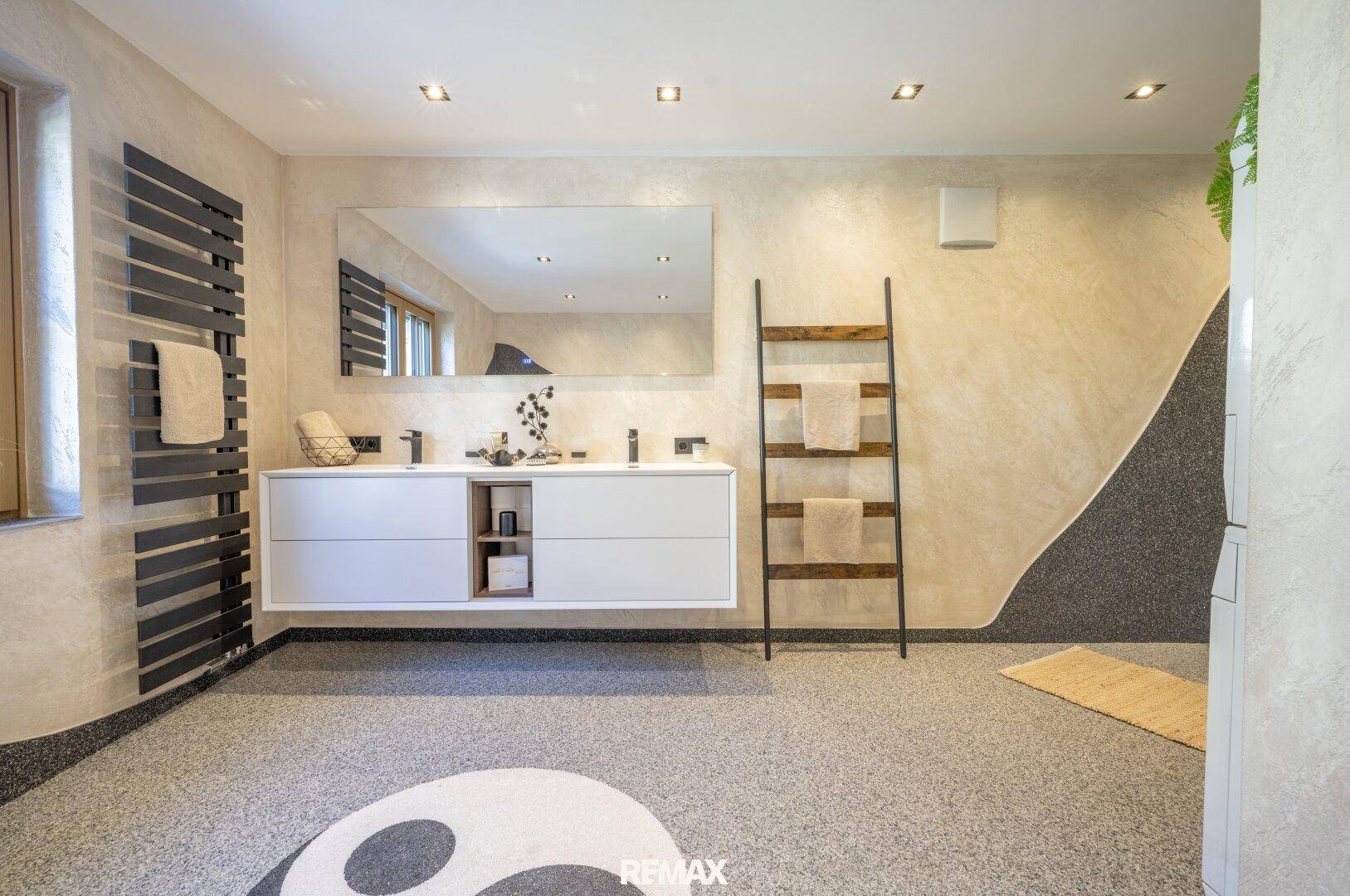 Modernes Badezimmer mit Doppelwaschbecken, großem Spiegel und beheiztem Handtuchhalter.
