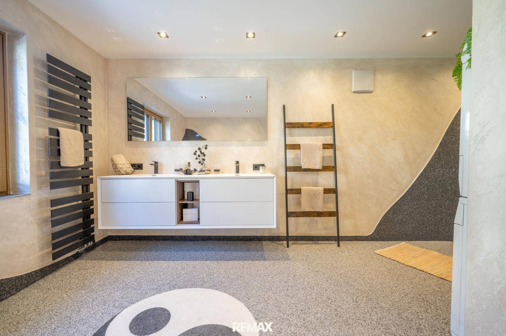 Modernes Badezimmer mit Doppelwaschbecken, großem Spiegel und beheiztem Handtuchhalter.
