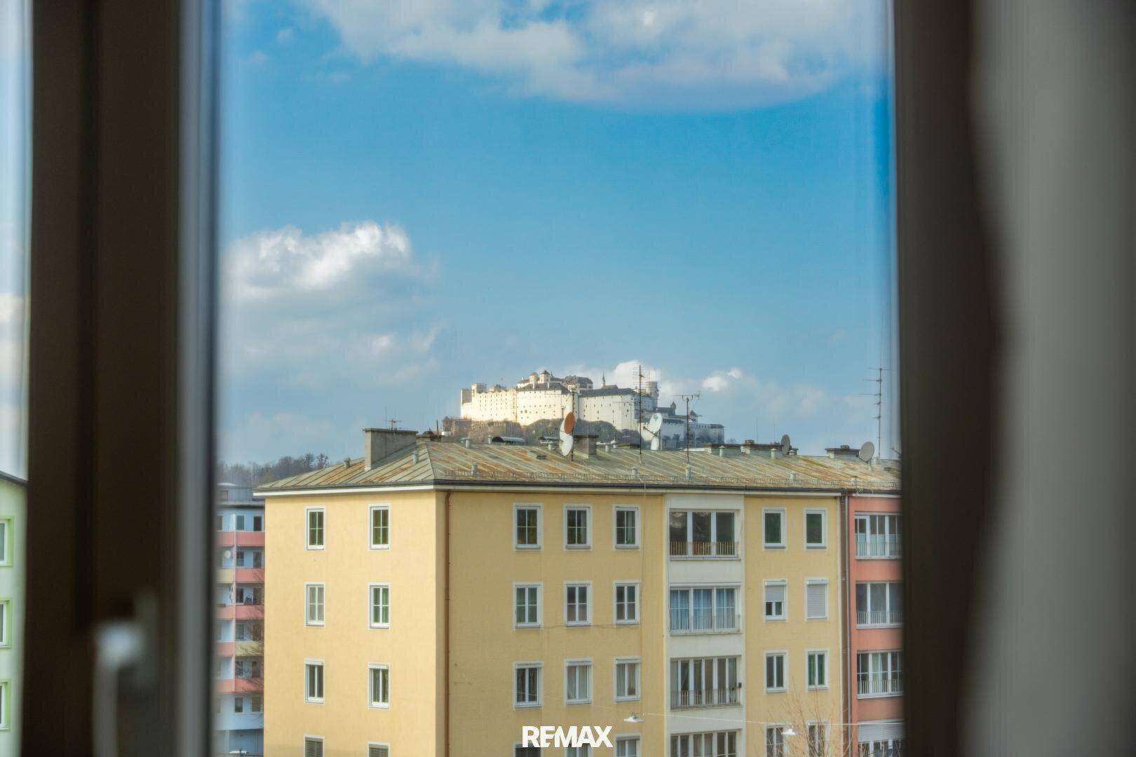Blick aus dem Fenster auf die umliegenden Gebäude und eine Burg auf dem Hügel.
