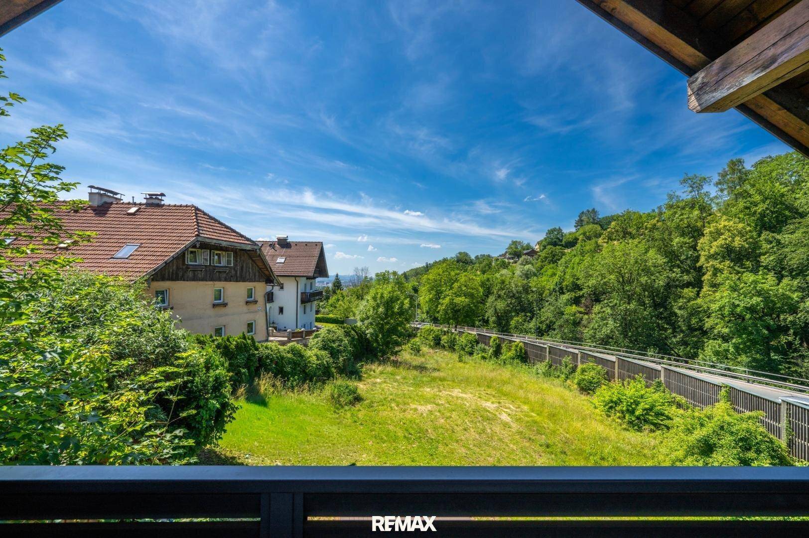 Weitläufiger Blick vom Balkon auf grüne Hügel und die umliegende Landschaft.