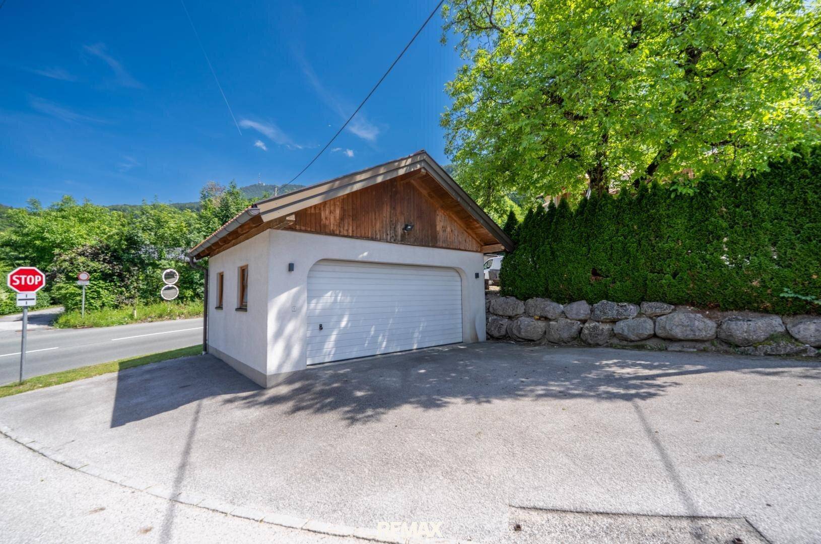 Separate Garage mit Satteldach und gepflasterter Zufahrt.