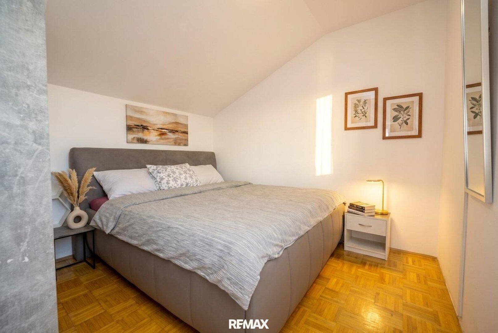 Gemütliches Schlafzimmer mit großem Doppelbett, Nachttischen und Dachschräge.