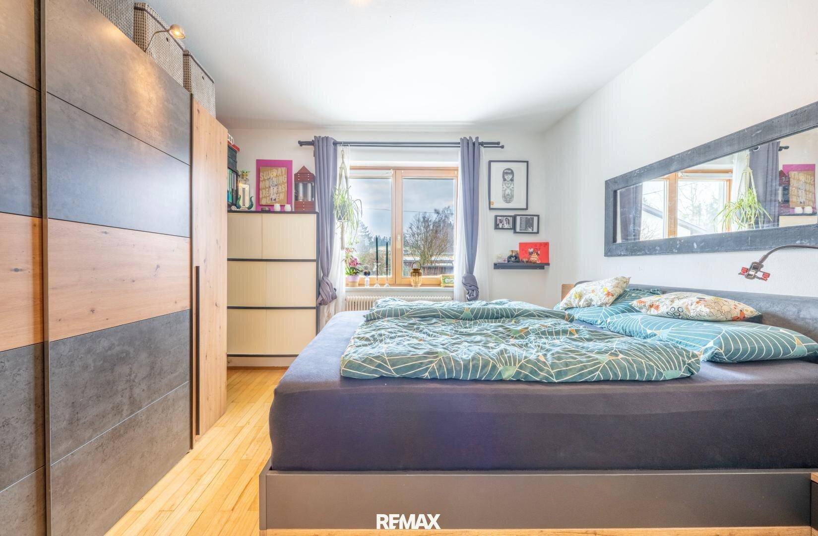 Schlafzimmer mit großem Bett, Einbauschränken und Fenster, modern und funktional eingerichtet.