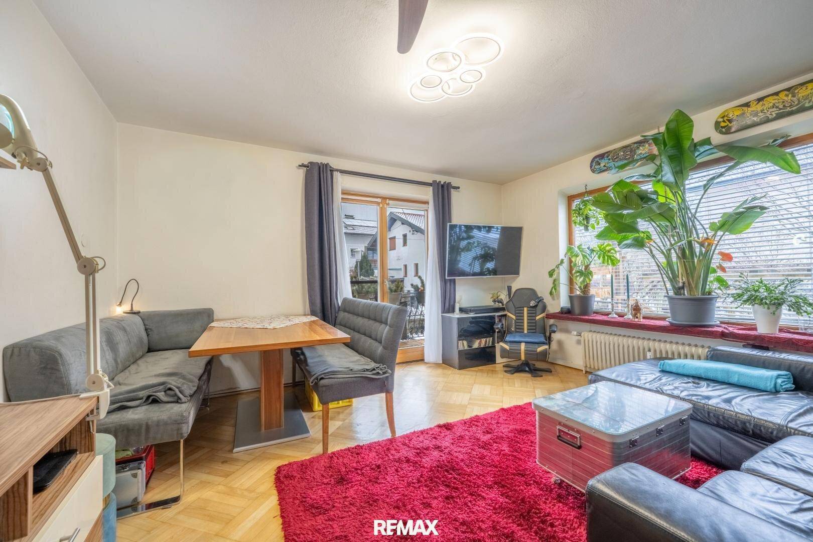 Wohnbereich mit Eckbank, Ledersofa und Zugang zum Balkon, hell und funktional eingerichtet.