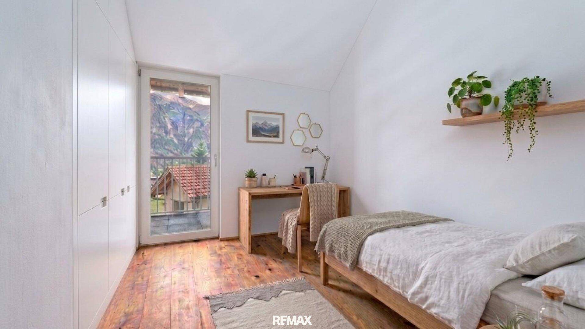 Gemütliches Schlafzimmer mit Einzelbett, Schreibtisch, Einbauschränken und Balkonzugang.