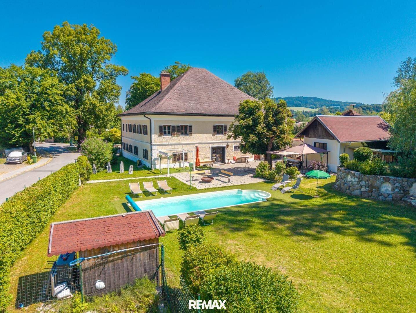 Luftaufnahme eines Anwesens mit großem Haus, Swimmingpool und weitläufigem Garten in ländlicher Umgebung.