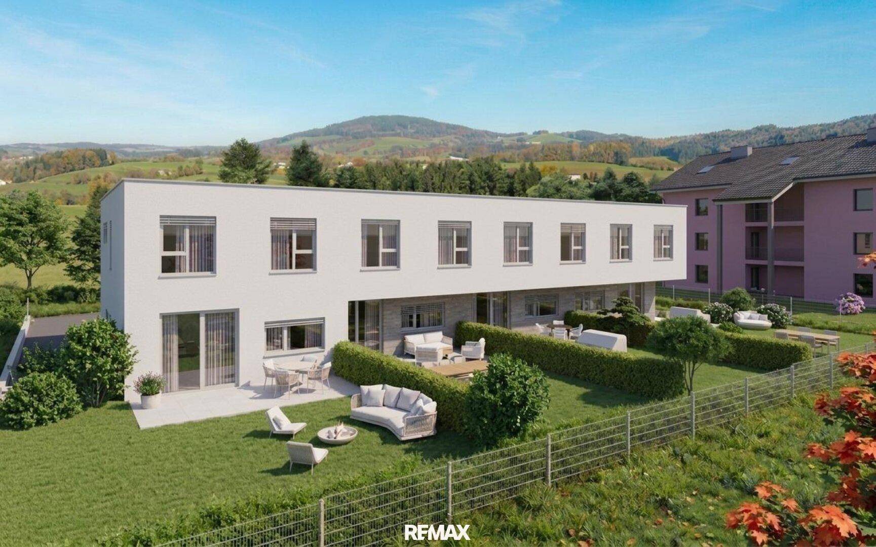 Ansicht der modernen Reihenhäuser mit privaten Gärten und Terrassen, umgeben von Natur.