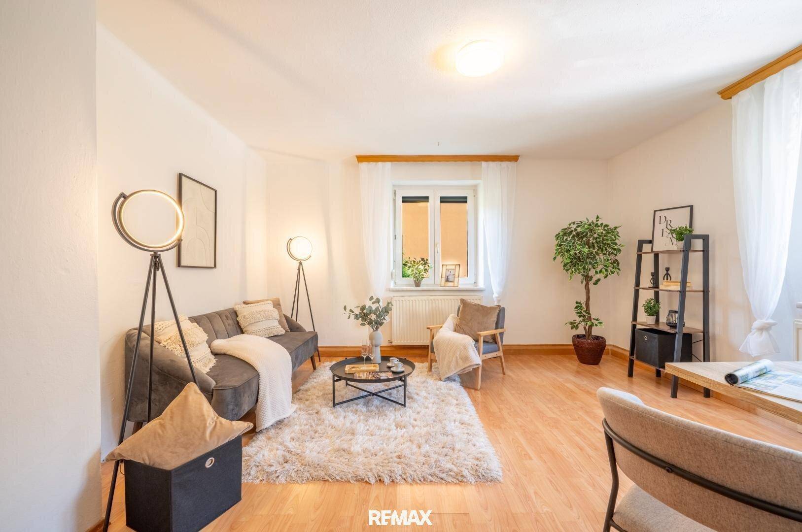 Gemütliches Wohnzimmer mit beigem Teppich, modernen Stehlampen und hellem Parkettboden.