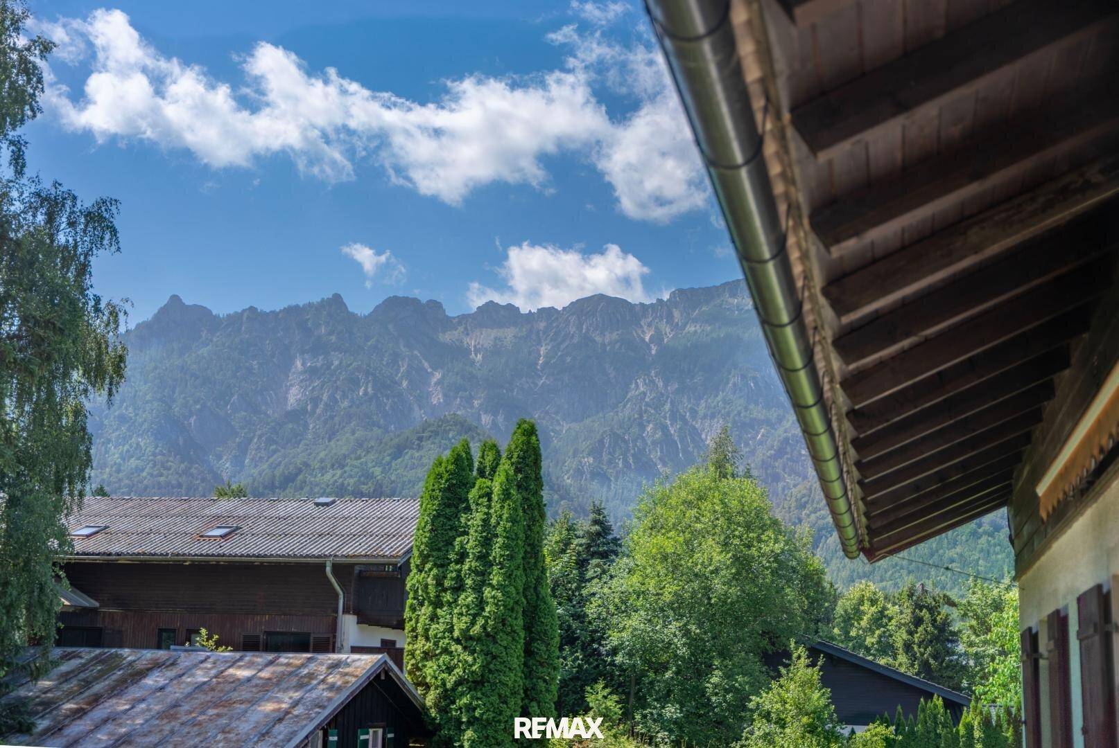 Malerischer Bergblick von der Immobilie mit grüner Umgebung und strahlend blauem Himmel.