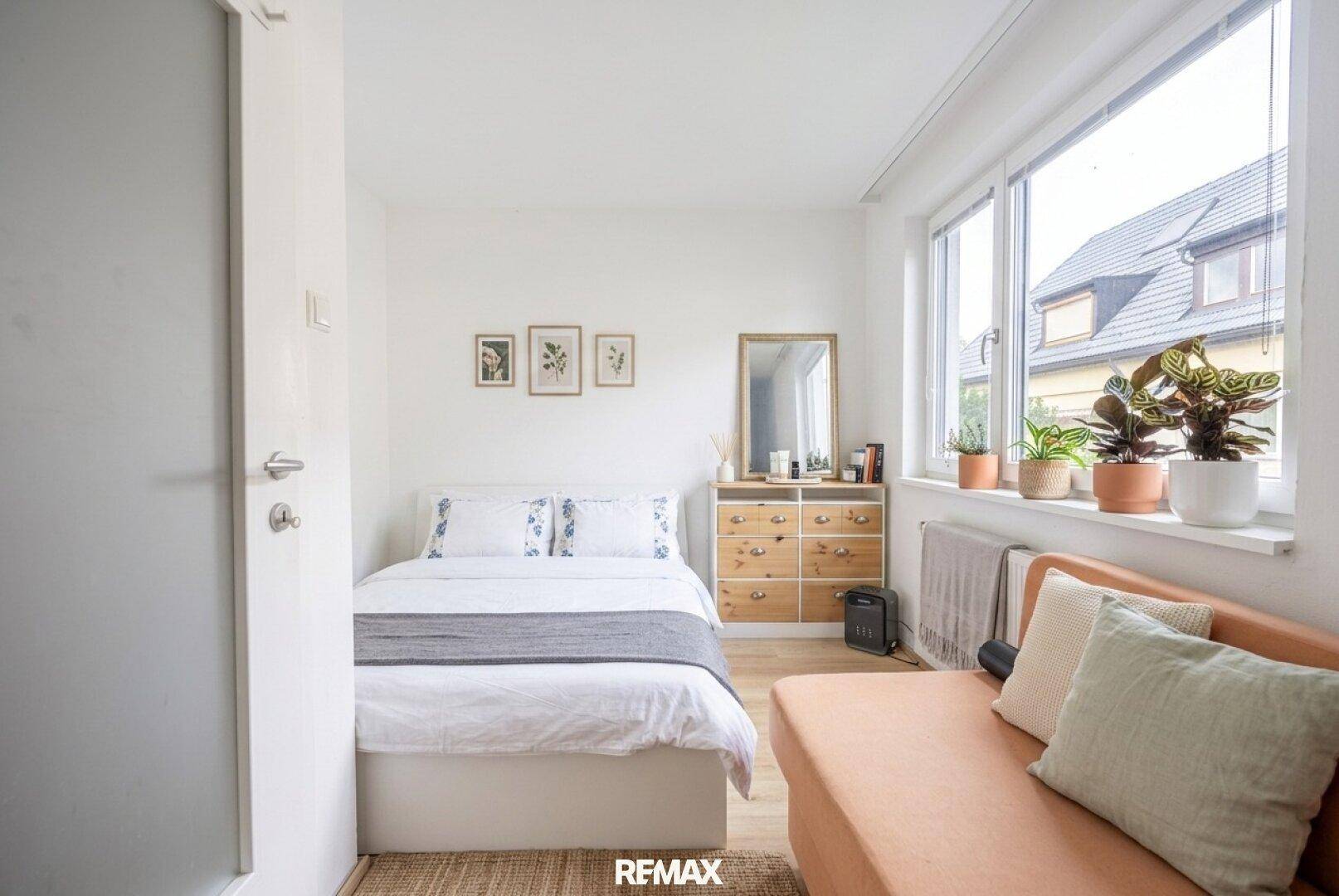 Gemütliches Schlafzimmer mit Einzelbett, hellem Interieur und Fenster mit Blick nach draußen.