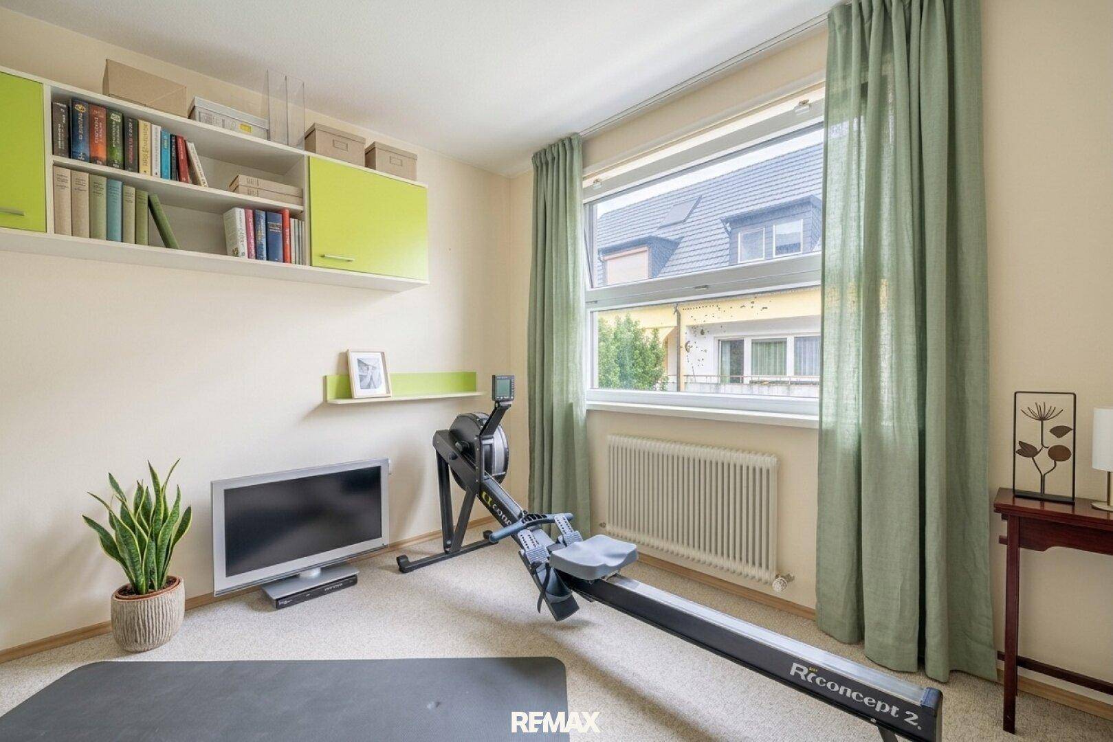 Vielseitiger Raum, eingerichtet als Home-Office oder Fitnessbereich mit Fenster.