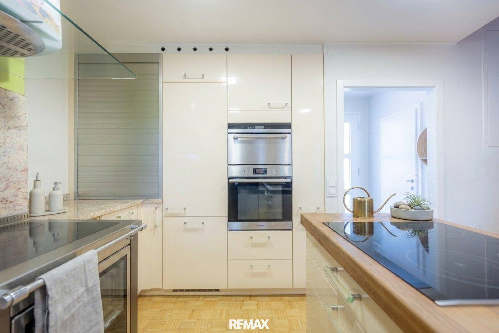 Moderne Einbauküche mit integriertem Backofen und Mikrowelle in Hochglanzoptik.