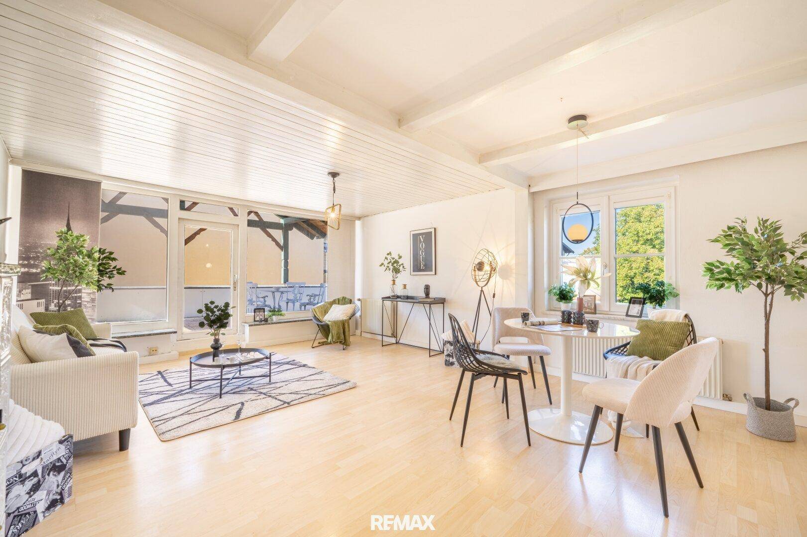 Helles und geräumiges Wohnzimmer mit Holzboden, weißer Deckenverkleidung und Loggia-Zugang.