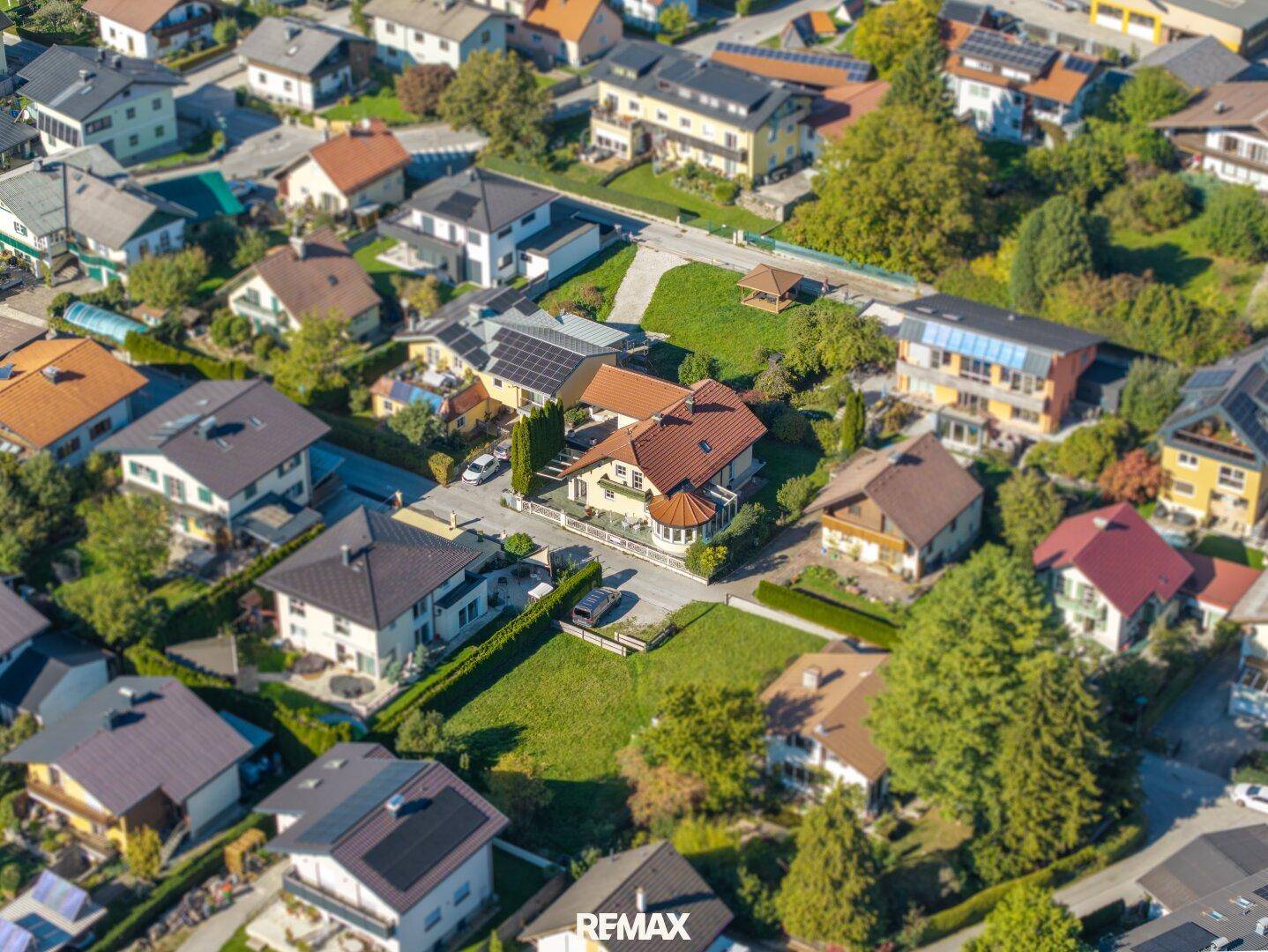 Luftaufnahme des Hauses in einer grünen Wohngegend mit umliegenden Gebäuden und Gärten.