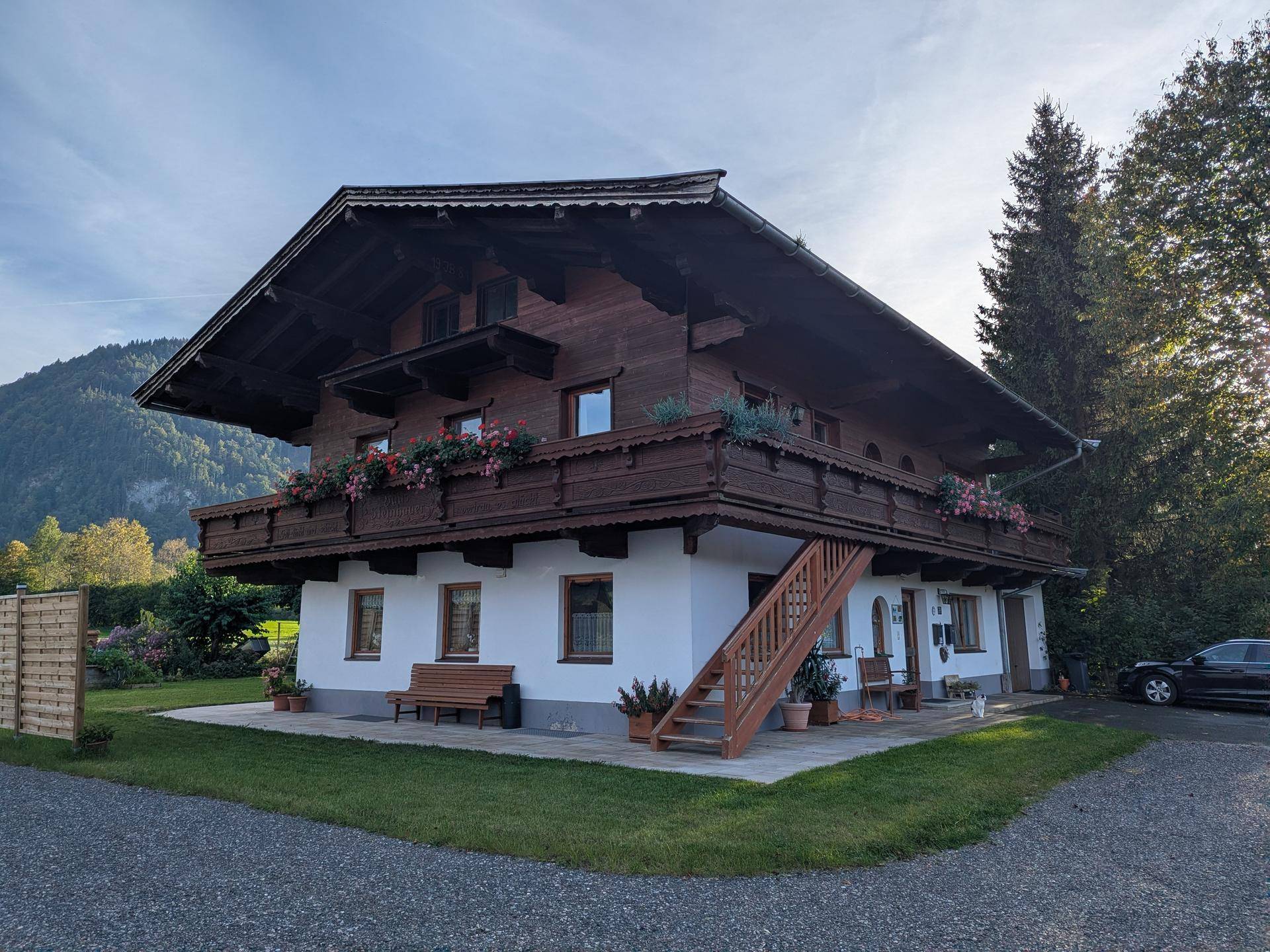Charmantes Alpenhaus mit traditioneller Holzfassade und Balkonen in ländlicher Umgebung.