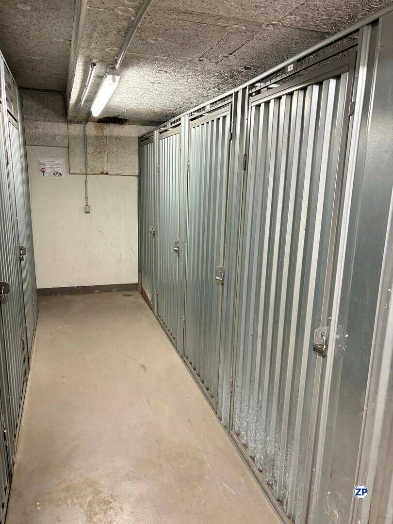 Abstellraum im Keller mit mehreren Metallschränken und Betonboden, ideal für Lagerzwecke.