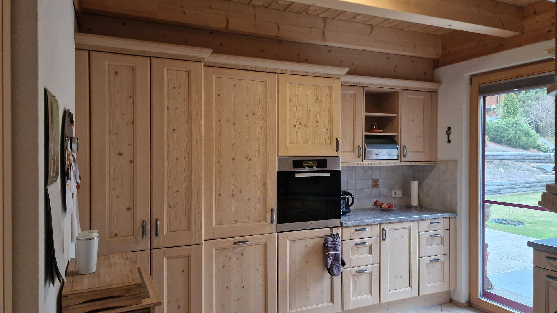 Geräumige Holzküche mit vielen Einbauschränken und integriertem Backofen.