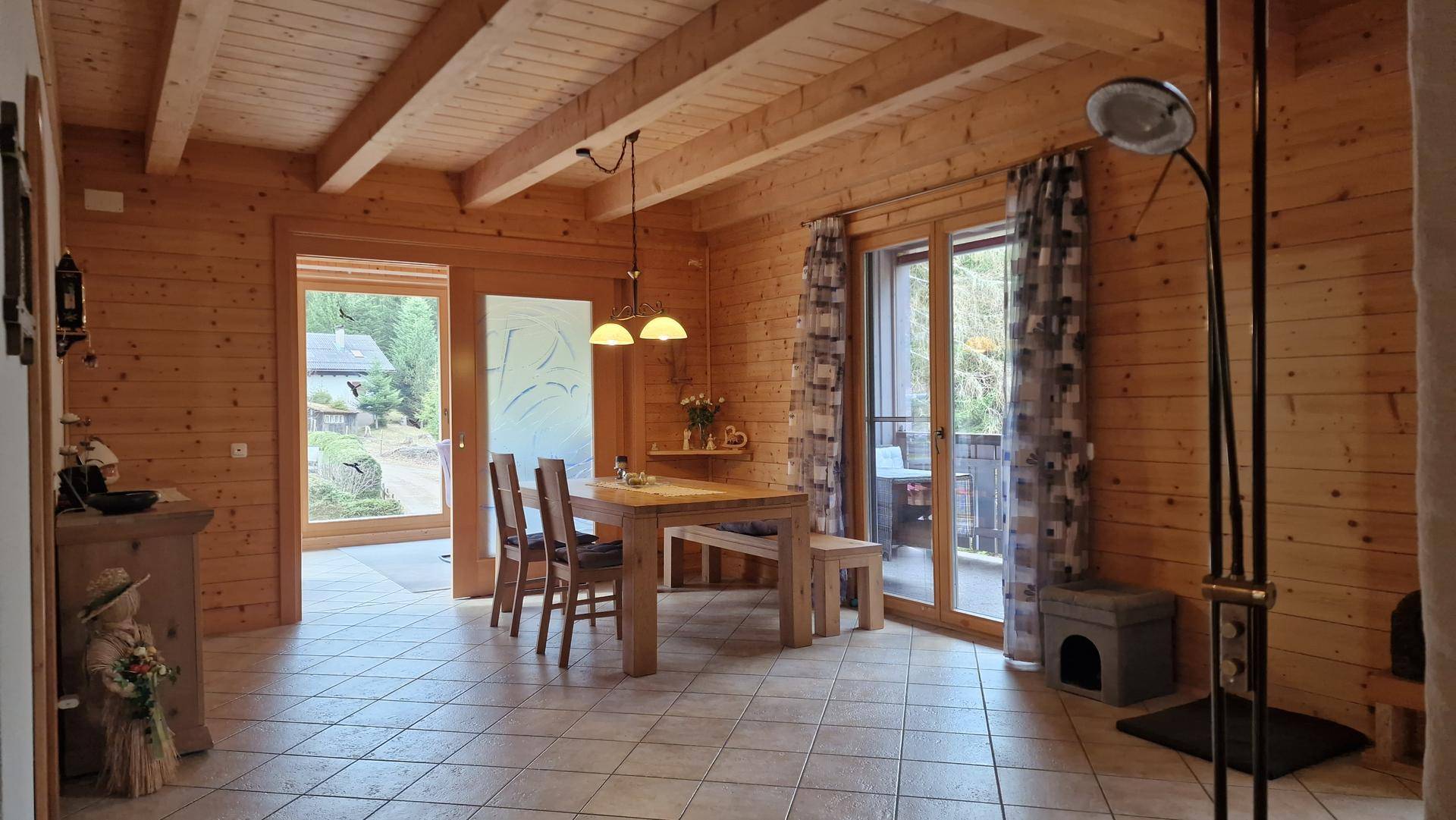 Heller Essbereich mit Holztisch, Stühlen und Zugang zum Balkon durch eine Glastür.