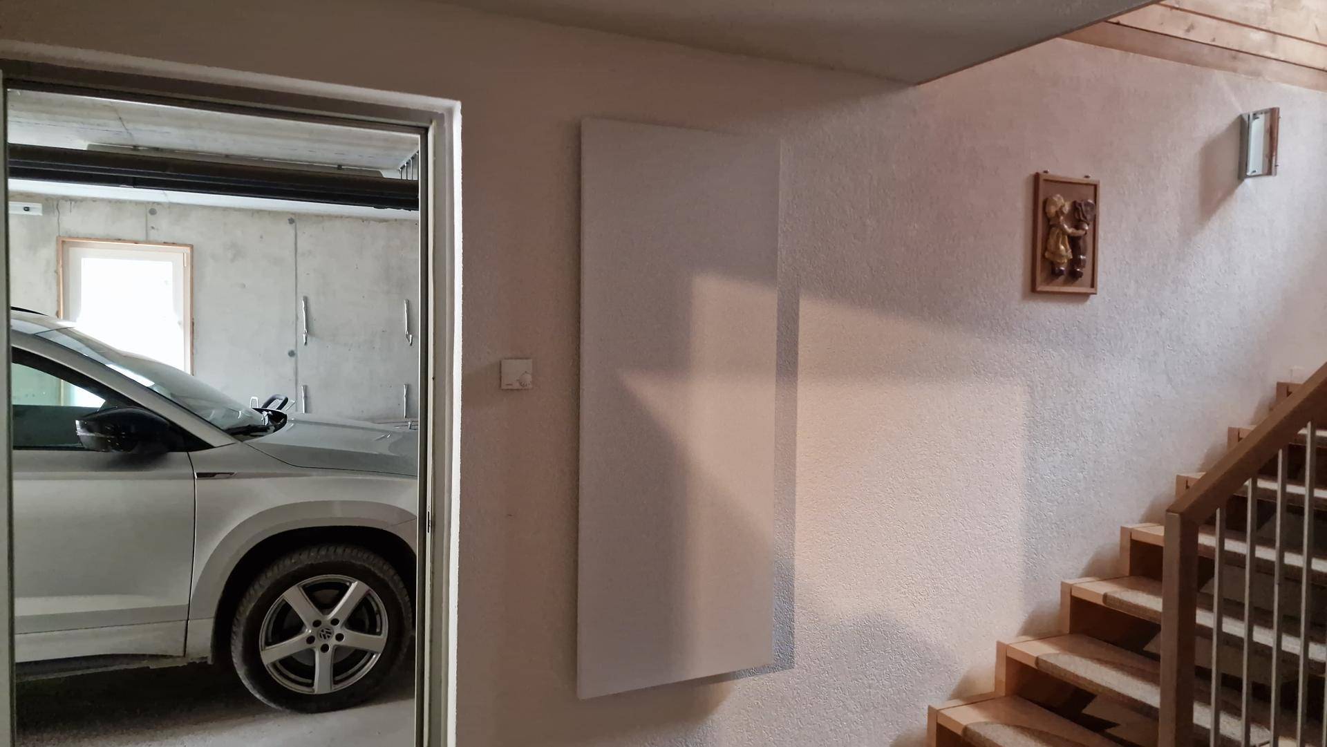 Heller Flurbereich mit Treppe und Infrarotheizung, angrenzend an die Garage.
