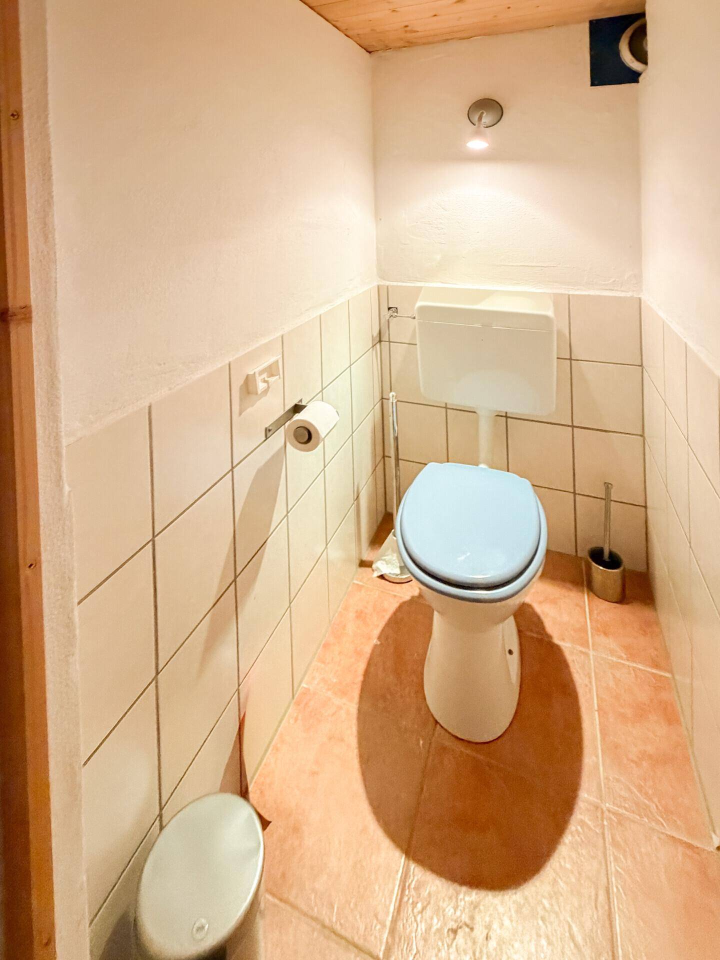 Separates WC mit Toilette, Bidet und hellen Wandfliesen sowie Terrakotta-Bodenfliesen.