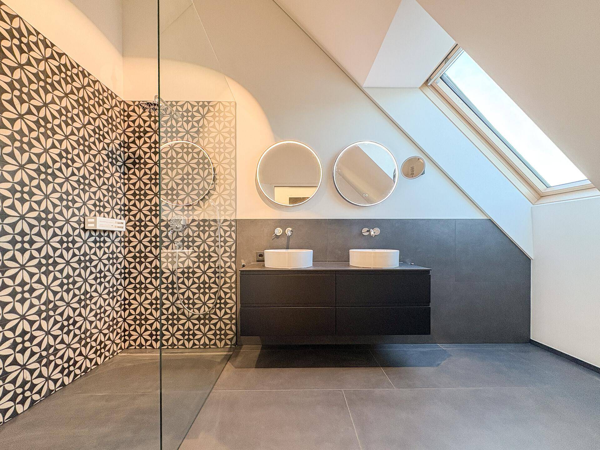 Helles Badezimmer im Dachgeschoss mit Dachfenster, begehbarer Dusche und Doppelwaschbecken.