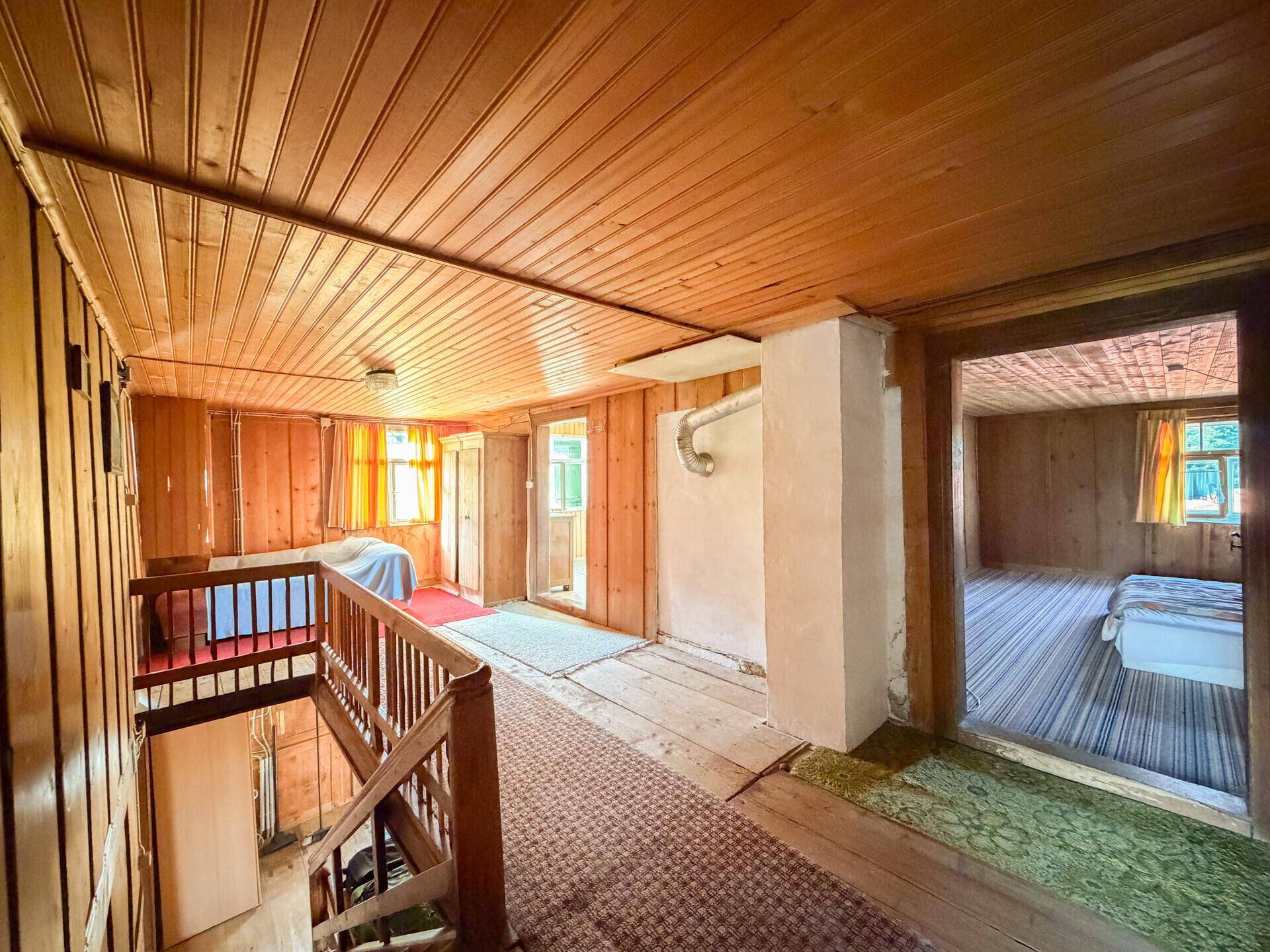 Heller Flur mit Holztäfelung, Treppenaufgang und Zugang zu weiteren Zimmern im Obergeschoss.