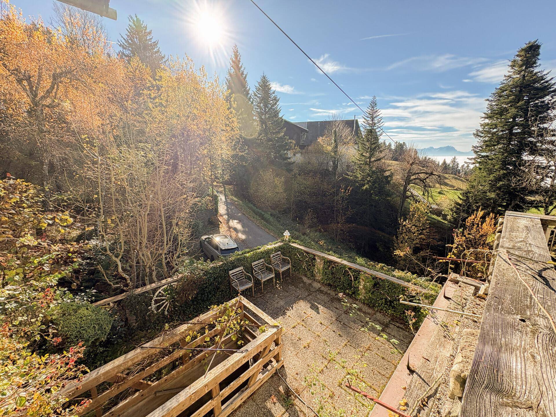 Weitläufiger Blick von der Terrasse auf die umliegende Natur und ferne Berge.