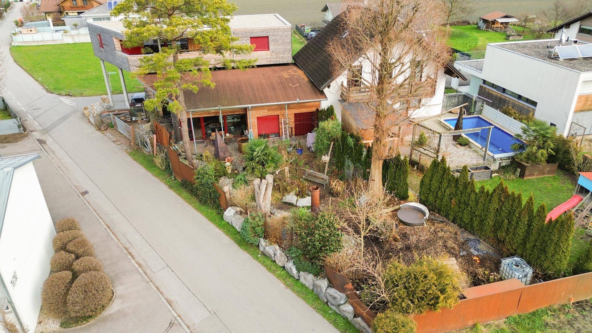 Luftaufnahme des Anwesens mit Garten, Pool und umliegender Wohnbebauung.