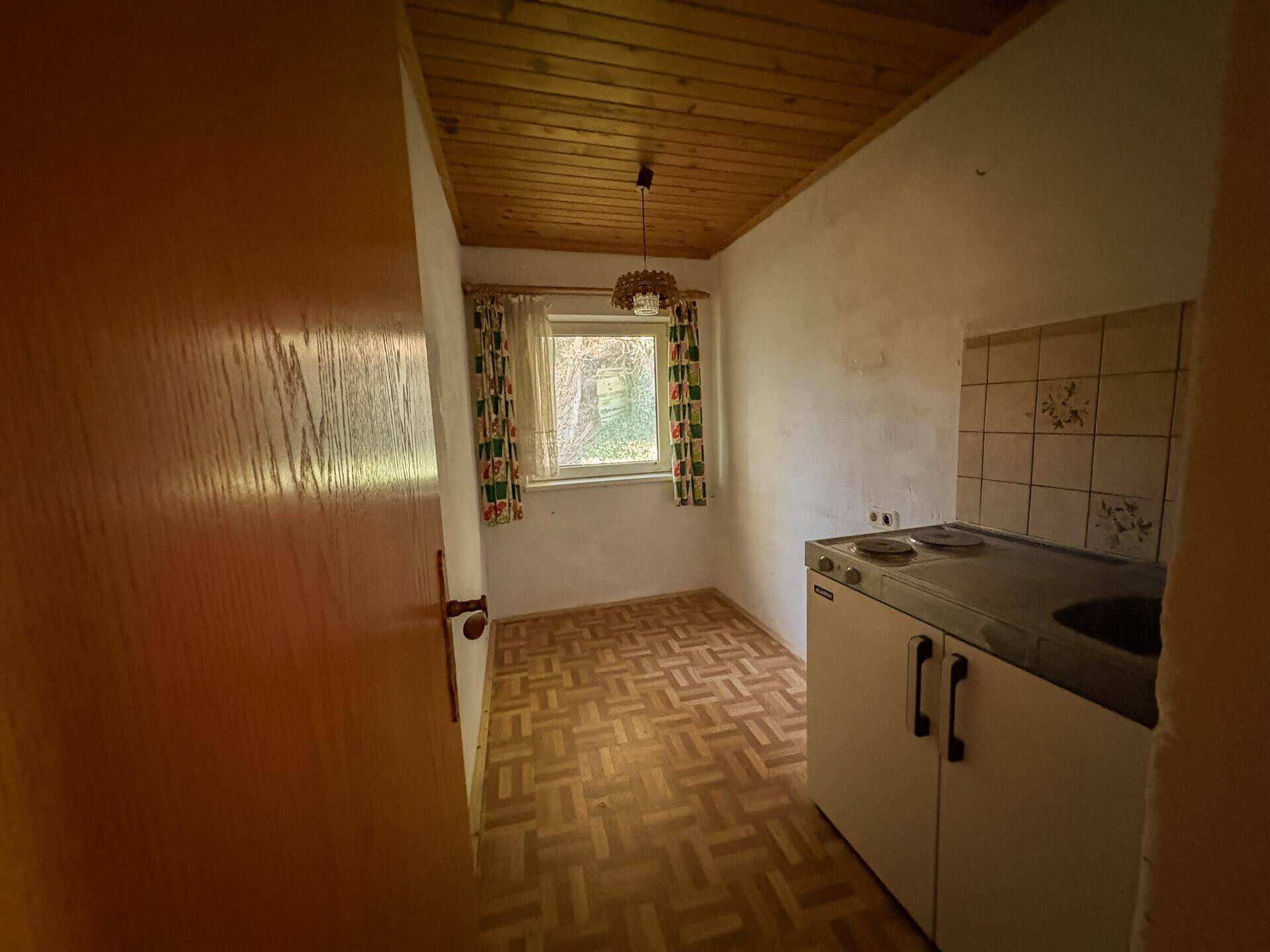 Kleine Kochnische mit einfacher Ausstattung und Fenster, ideal für ein Gästezimmer.