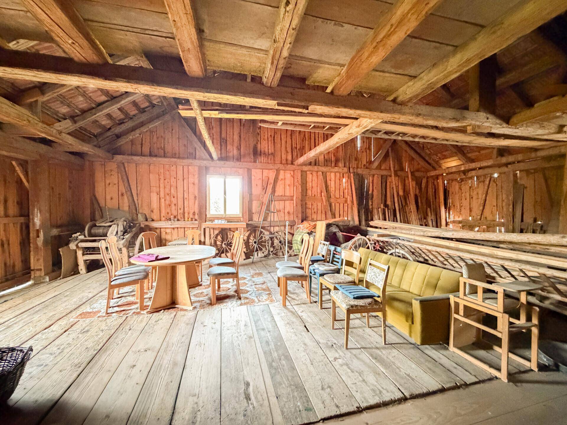 Geräumiger Dachboden mit sichtbaren Holzbalken, Holzdielenboden und viel Stauraum.