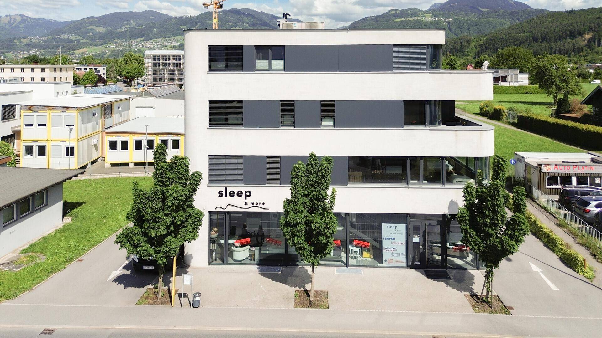 Ansicht der modernen Geschäftsfassade mit großen Fenstern und dem Schriftzug des Unternehmens.