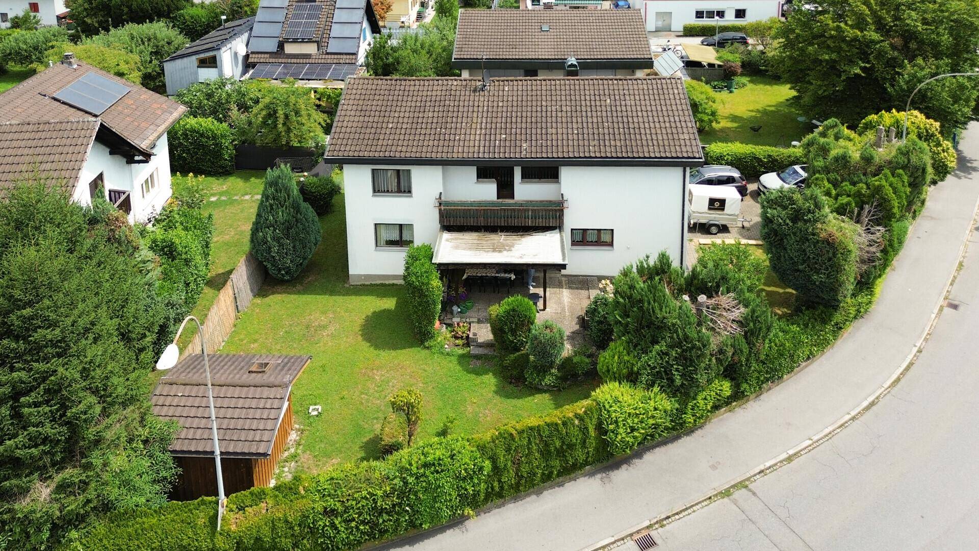 Vogelperspektive eines Wohnhauses mit großem Garten, umgeben von Hecken und Bäumen.