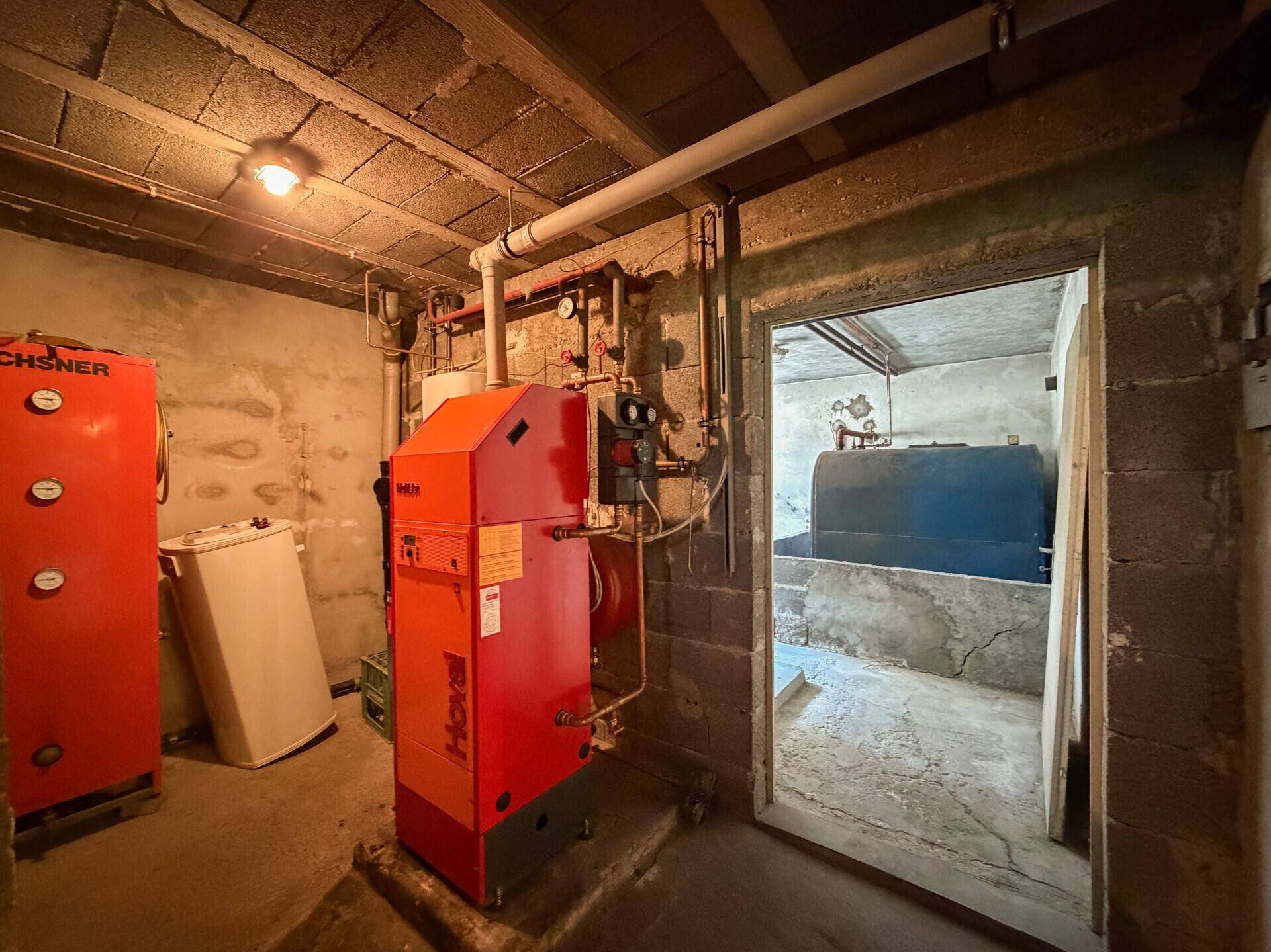 Heizungsraum im Keller mit Heizkessel und weiteren Installationen, funktional und geräumig.