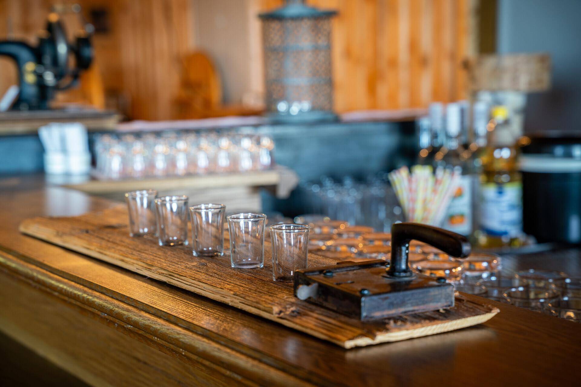 Rustikale Bar mit Holzelementen und Gläsern, bereit für den Ausschank in gemütlicher Atmosphäre.