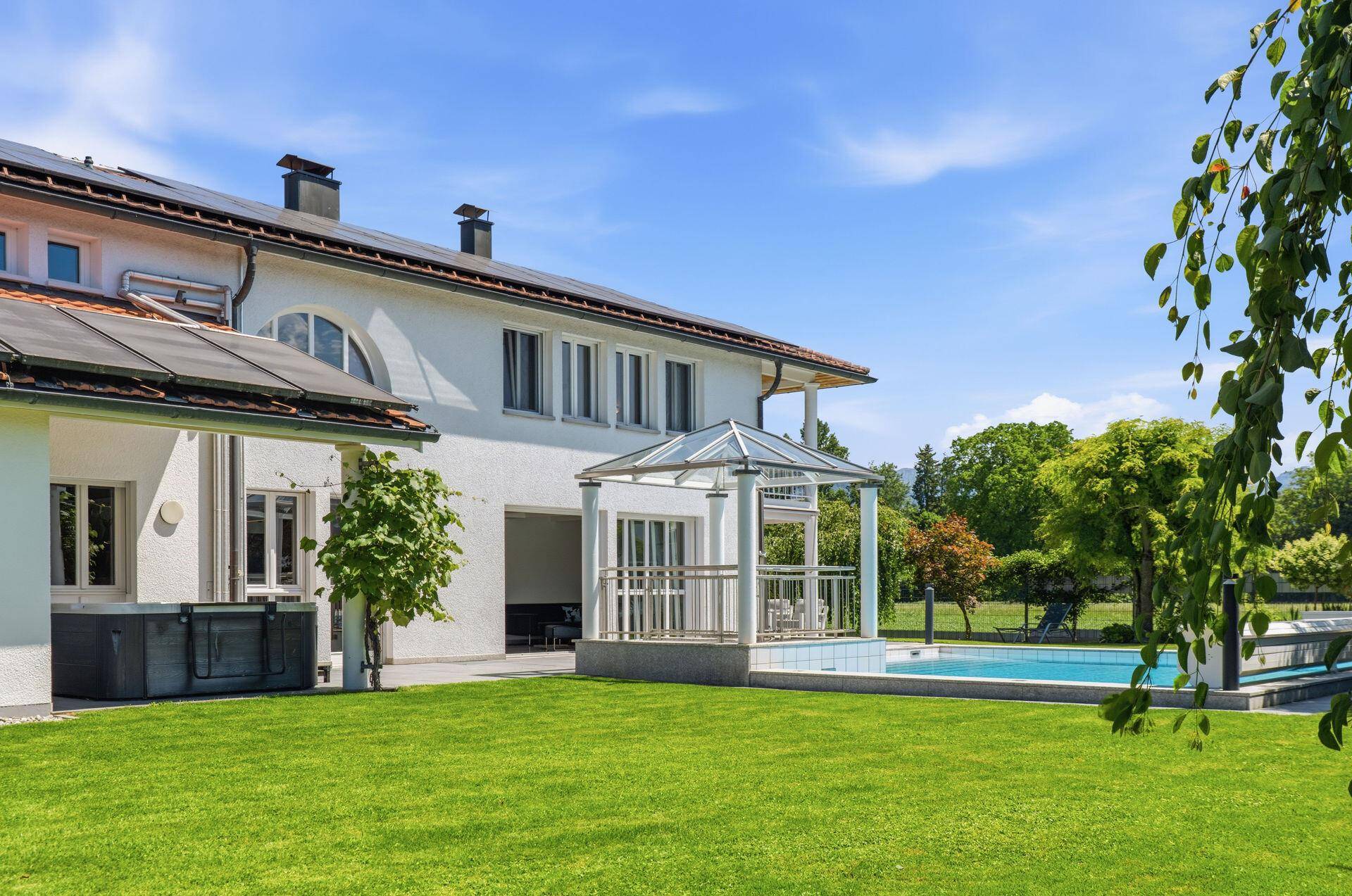 Weitläufiger Gartenbereich mit Rasenfläche, Pool und Blick auf die Umgebung.