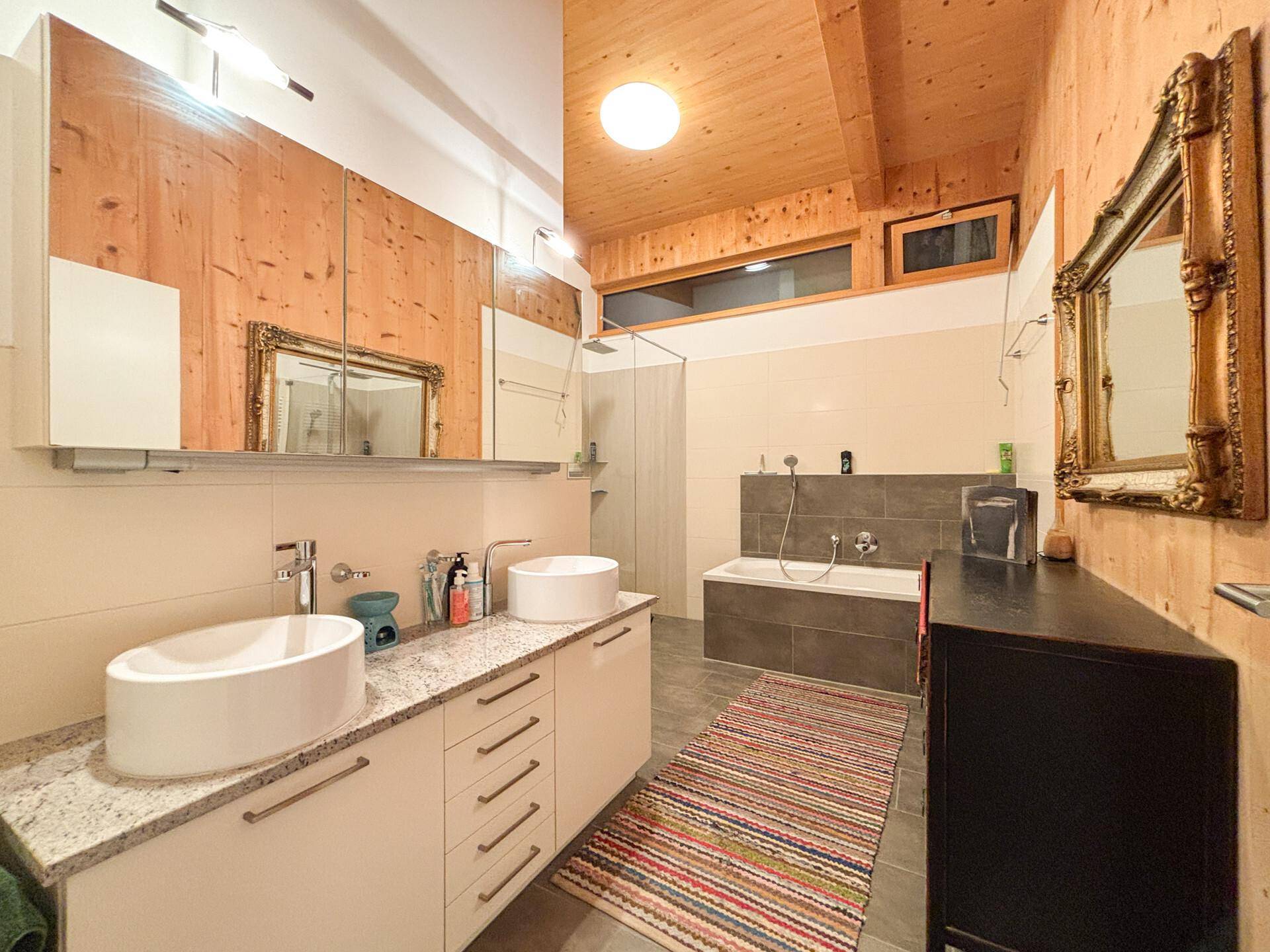 Modernes Badezimmer mit Doppelwaschbecken, Badewanne und separater Dusche.