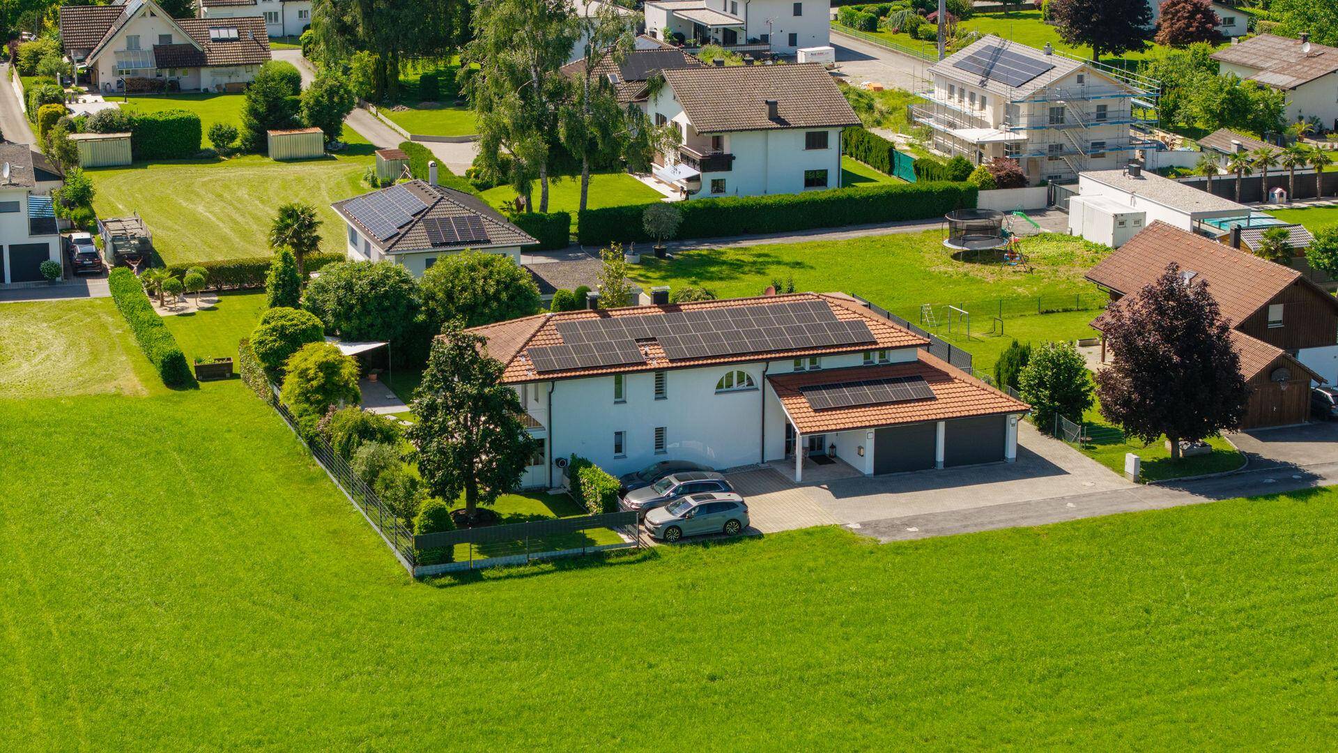 Luftaufnahme des Anwesens mit Photovoltaikanlage und gepflegtem Garten in ländlicher Umgebung.