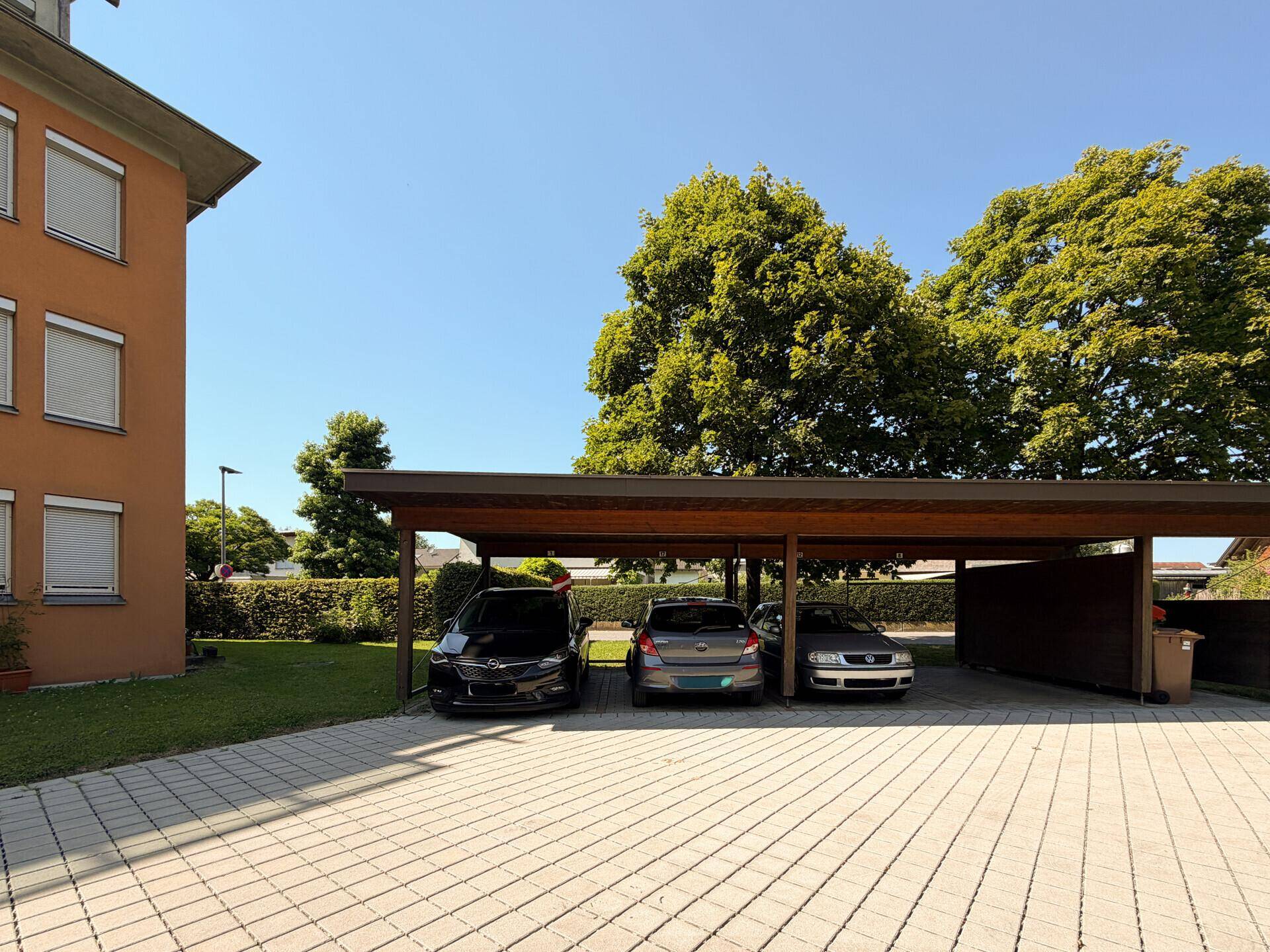 Überdachter Carport-Bereich mit mehreren Stellplätzen neben dem Gebäude.