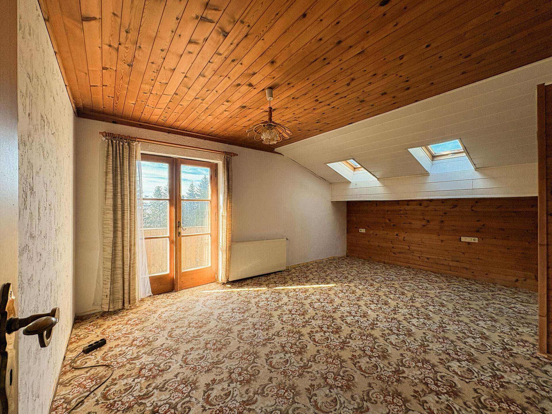 Schlafzimmer mit Teppichboden, Holzdecke und Dachfenstern für zusätzliches Licht.