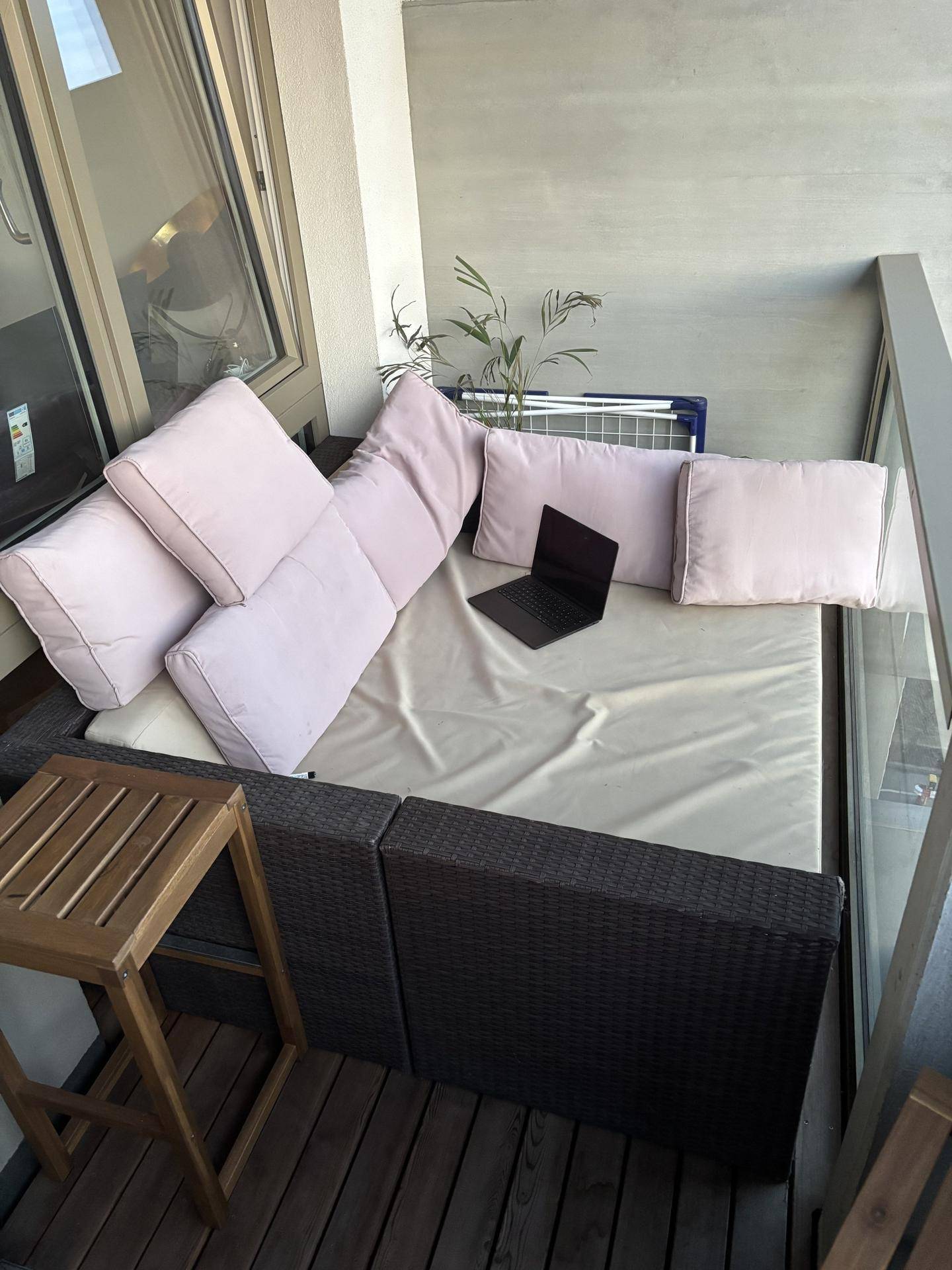 Gemütlicher Balkon mit Outdoor-Sofa und Holzboden, ideal zum Entspannen im Freien.