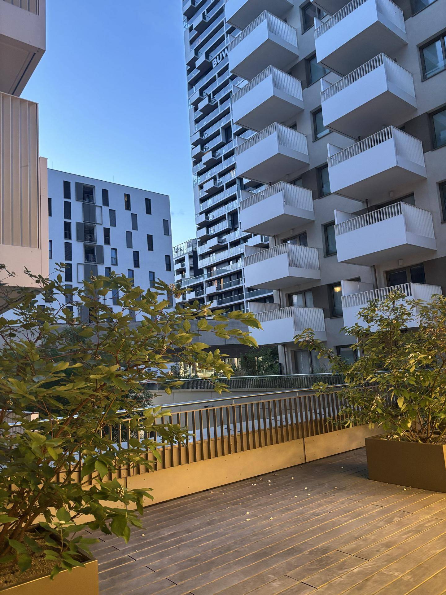 Moderne Wohngebäude mit zahlreichen Balkonen, umgeben von einer gepflegten Außenanlage.