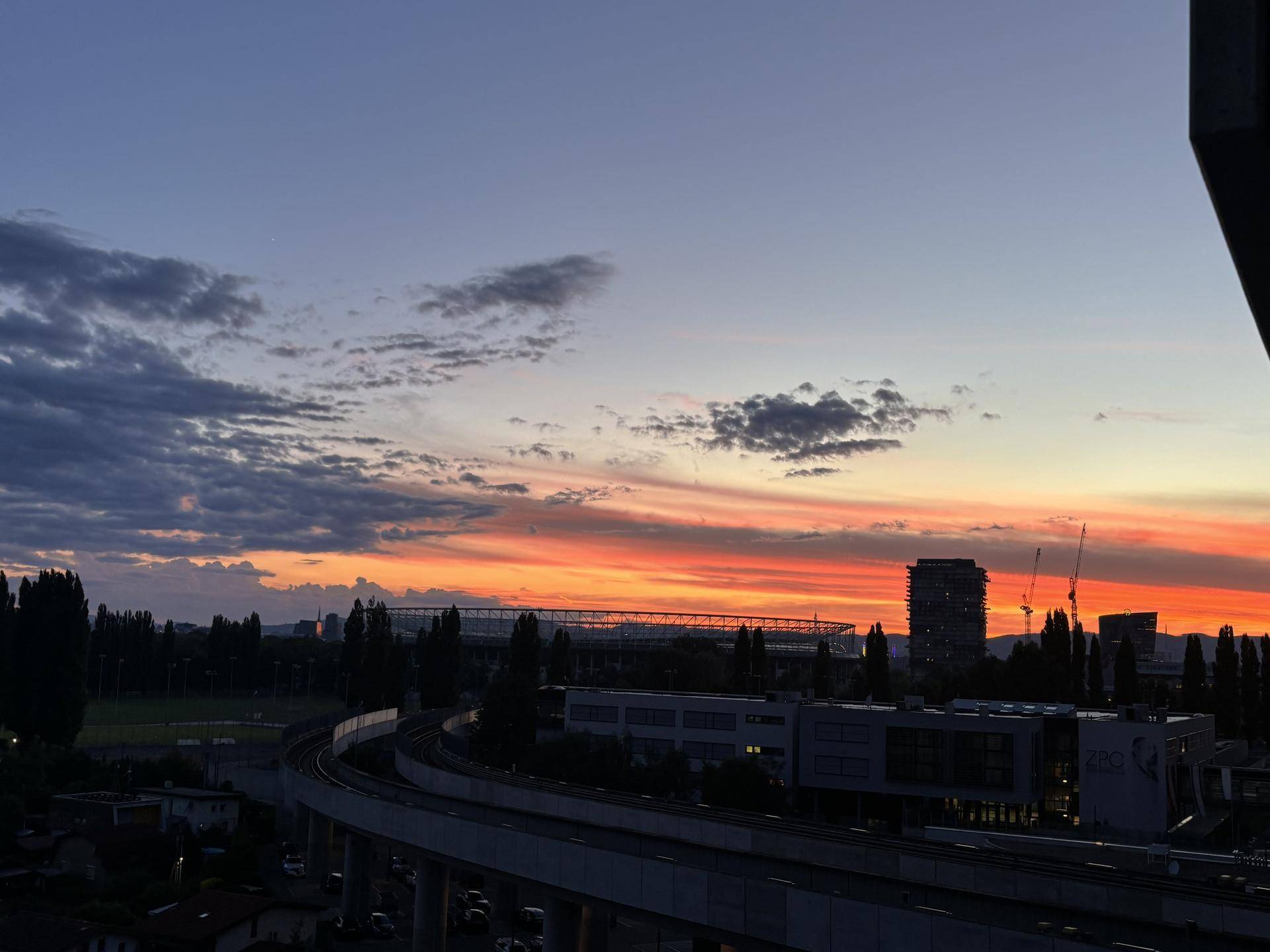 Spektakulärer Sonnenuntergang mit leuchtenden Farben über der Stadt und der umliegenden Landschaft.