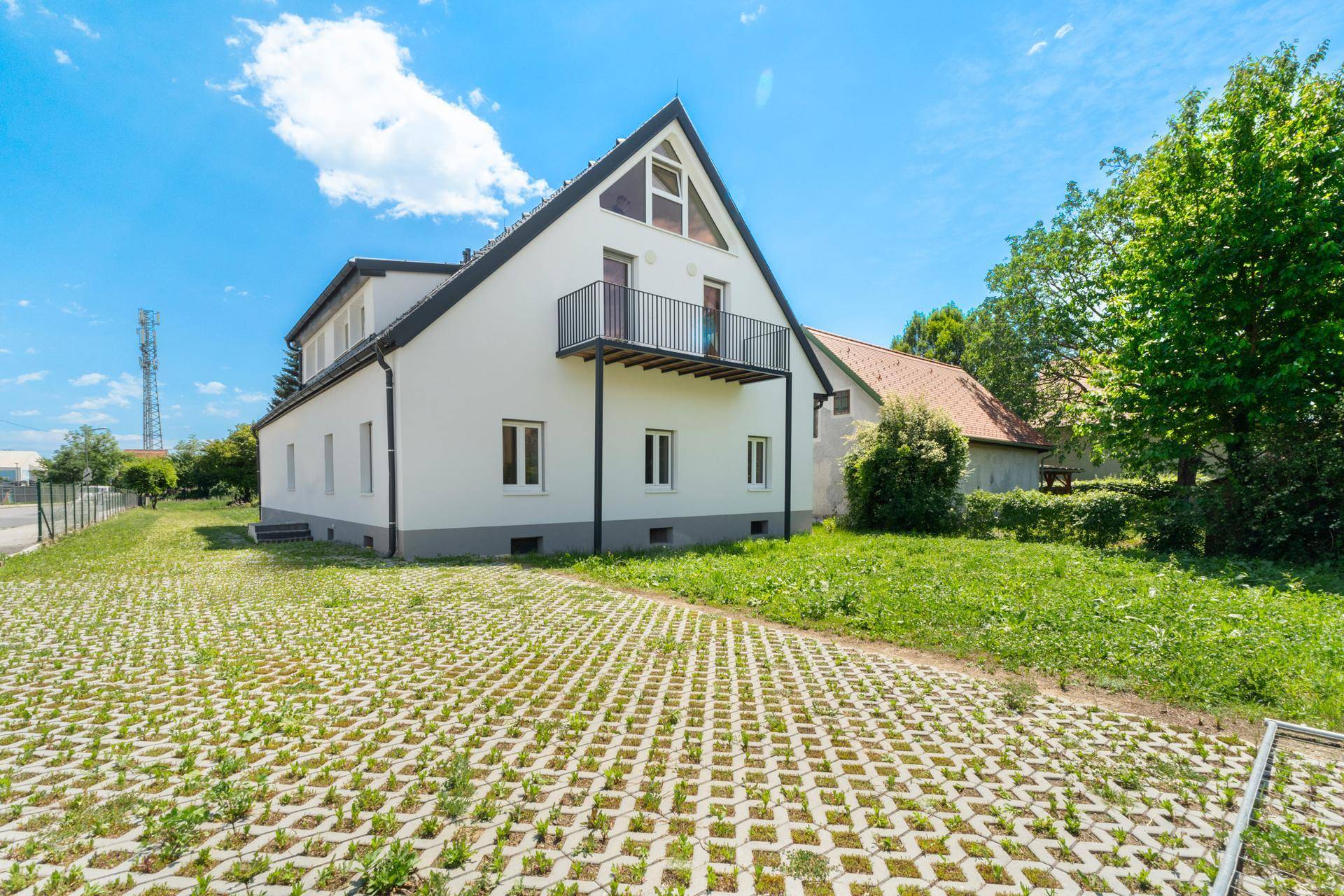 Hinterer Bereich des Hauses mit Rasengittersteinen und einer großen Rasenfläche.
