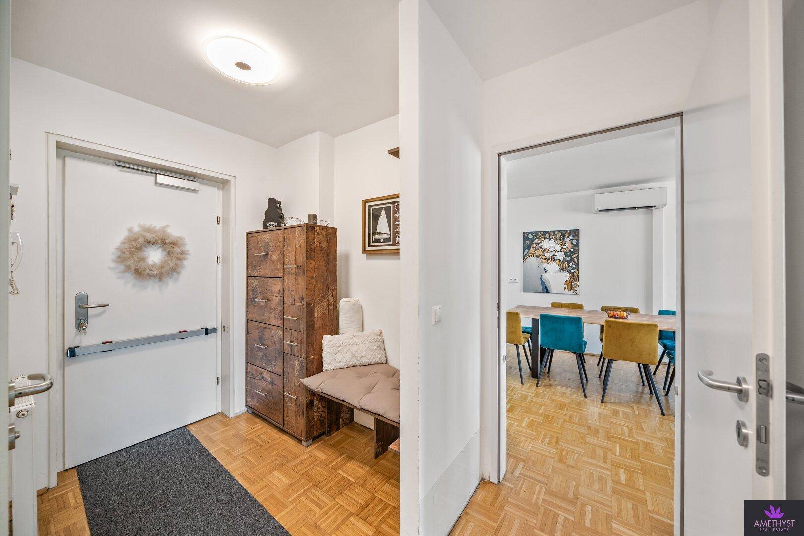 Eingangsbereich mit Parkettboden, Garderobe und Zugang zum Wohnbereich.