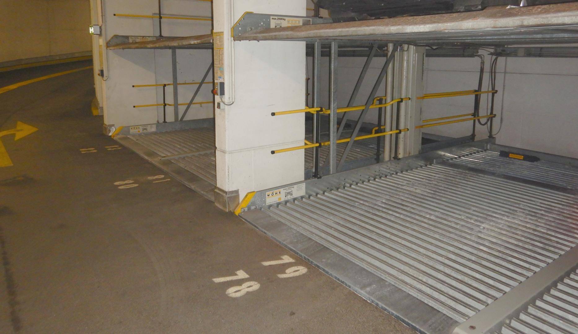 Tiefgarage mit mechanischen Parksystemen für platzsparendes Abstellen von Fahrzeugen auf zwei Ebenen.