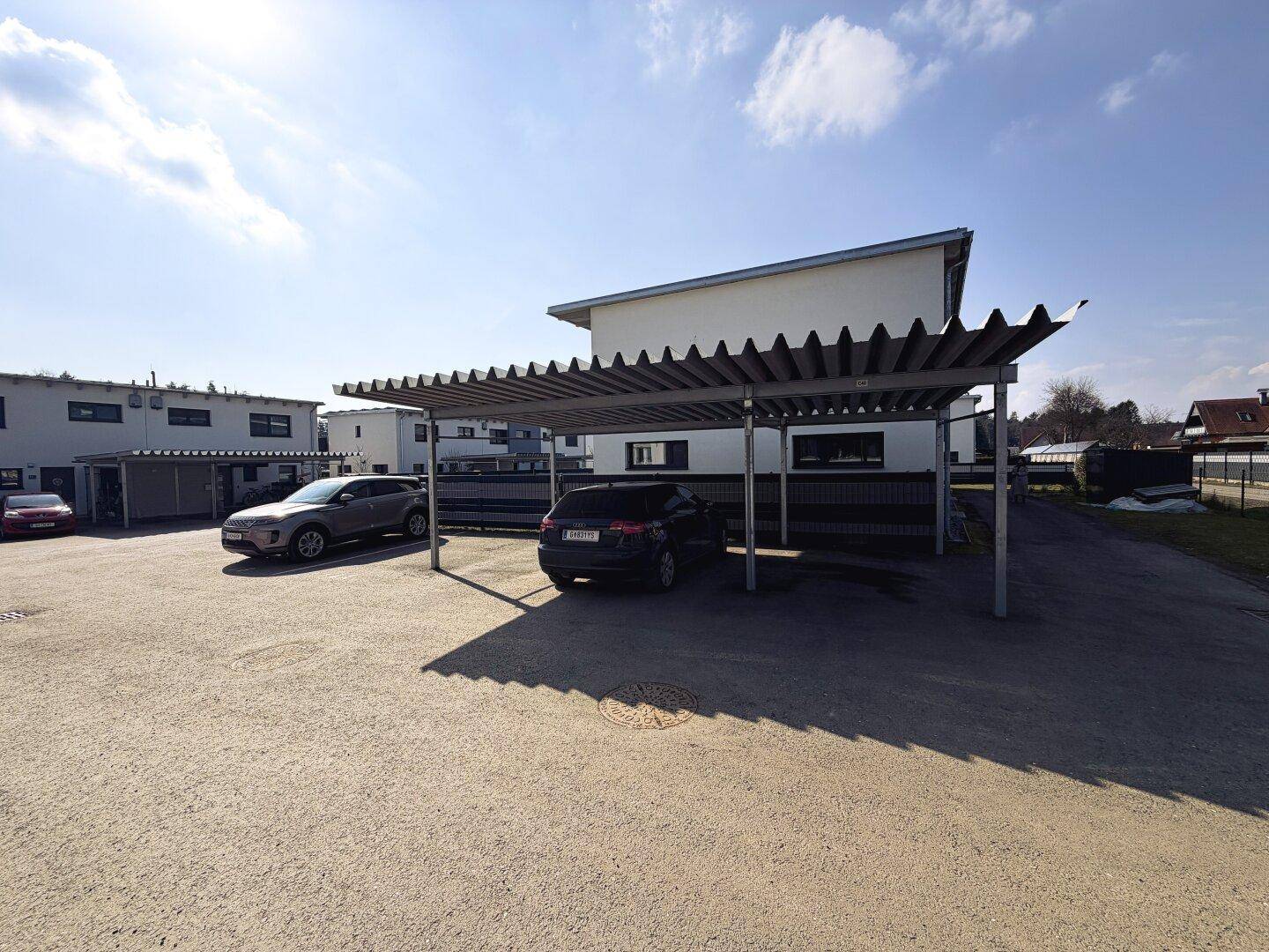 Überdachte Parkplätze (Carports) für mehrere Fahrzeuge, bieten Schutz vor Witterungseinflüssen.