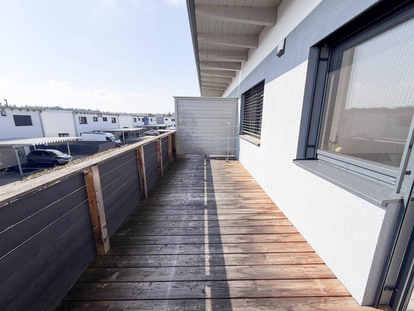 Langer Holzbalkon mit Blick auf die Umgebung und ausreichend Platz für Entspannung im Freien.