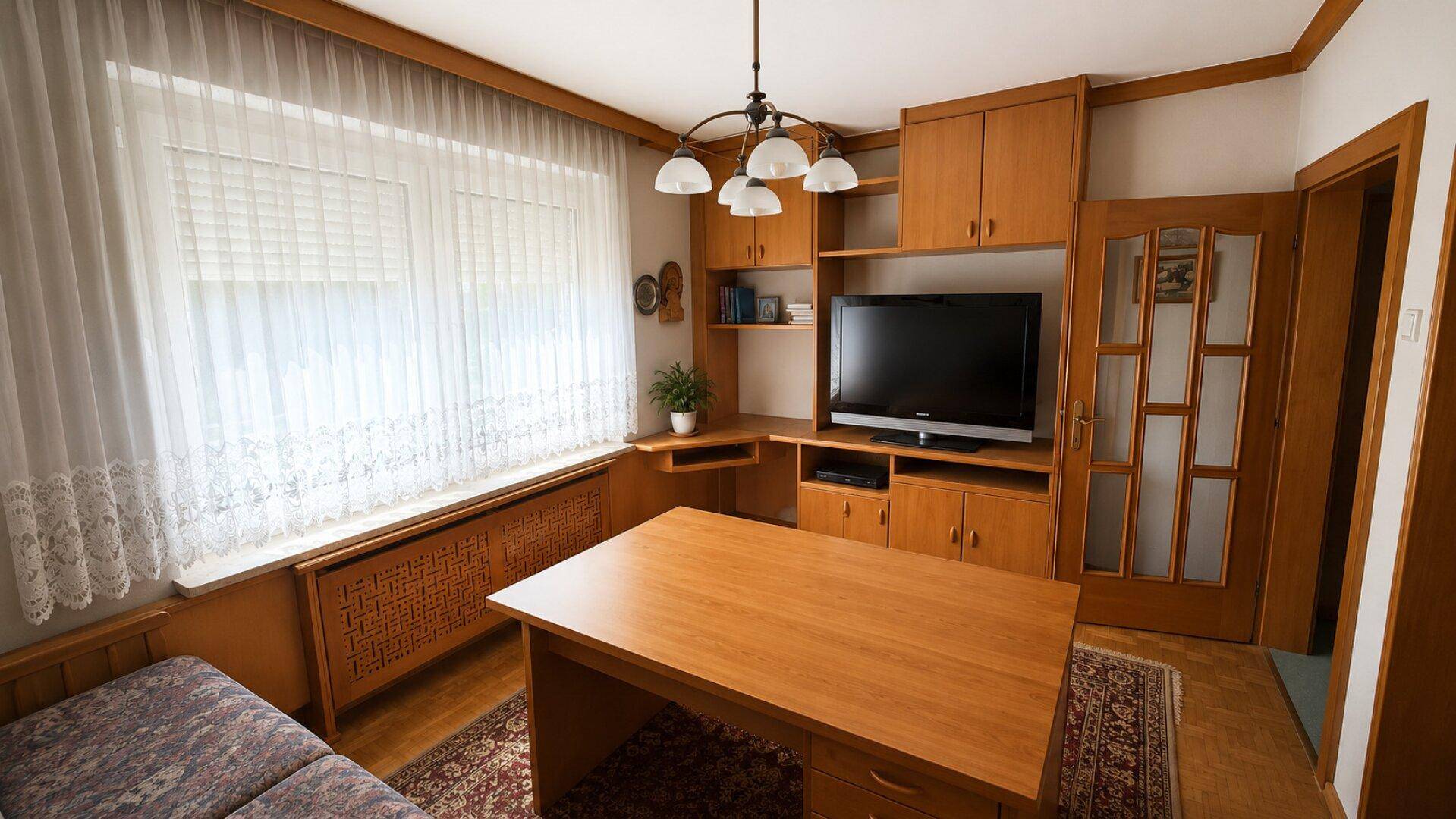 Funktionales Arbeitszimmer mit Schreibtisch, Sofa und integrierten Holzschränken, gut organisiert.