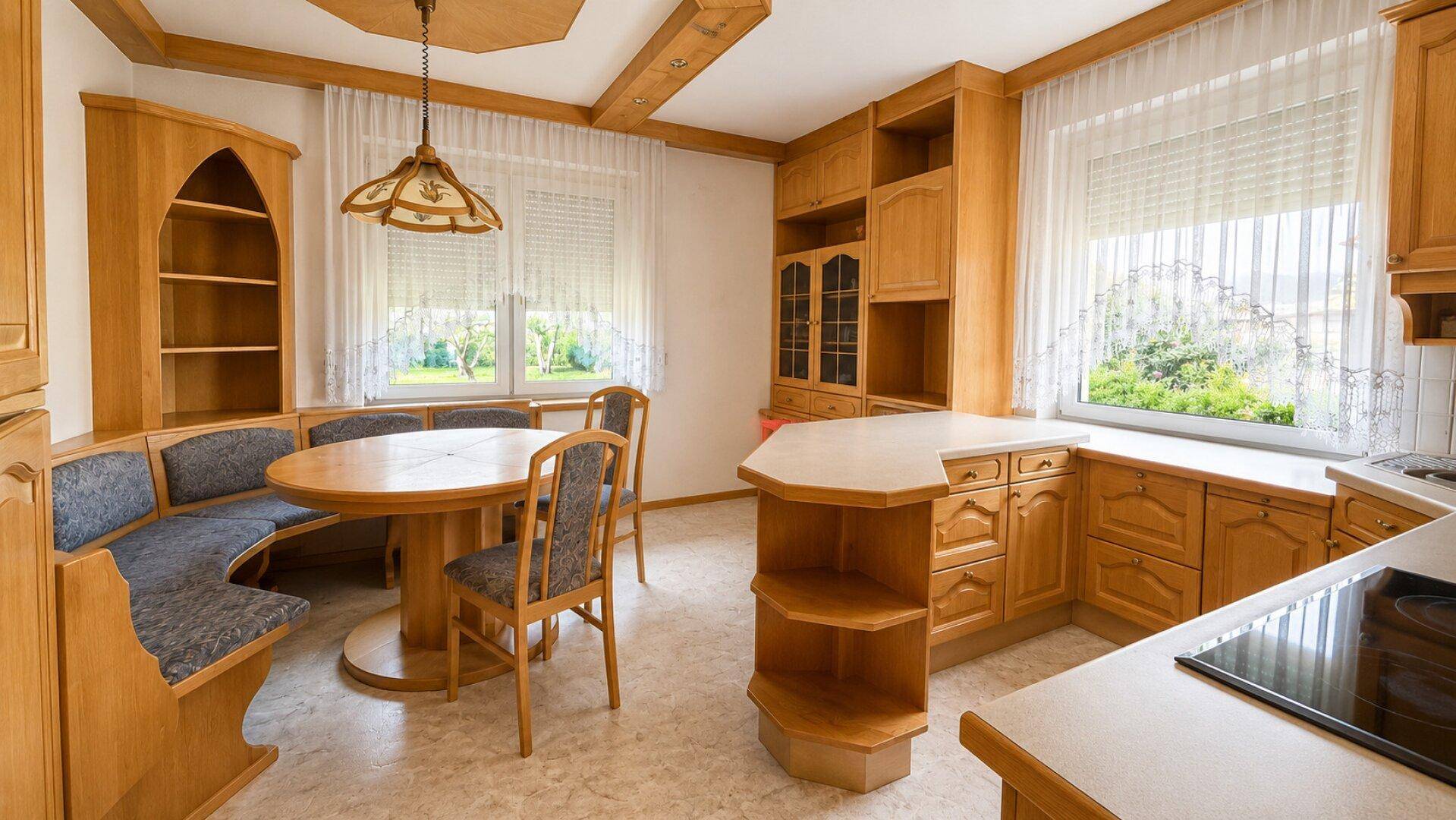 Gemütliche Wohnküche mit Holzeinrichtung, Eckbank und viel Tageslicht, ideal für Familienessen.